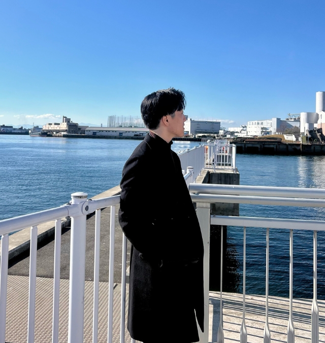 開放的な背景と落ち着いた服装で、あえて顔を出さず雰囲気を伝える写真
