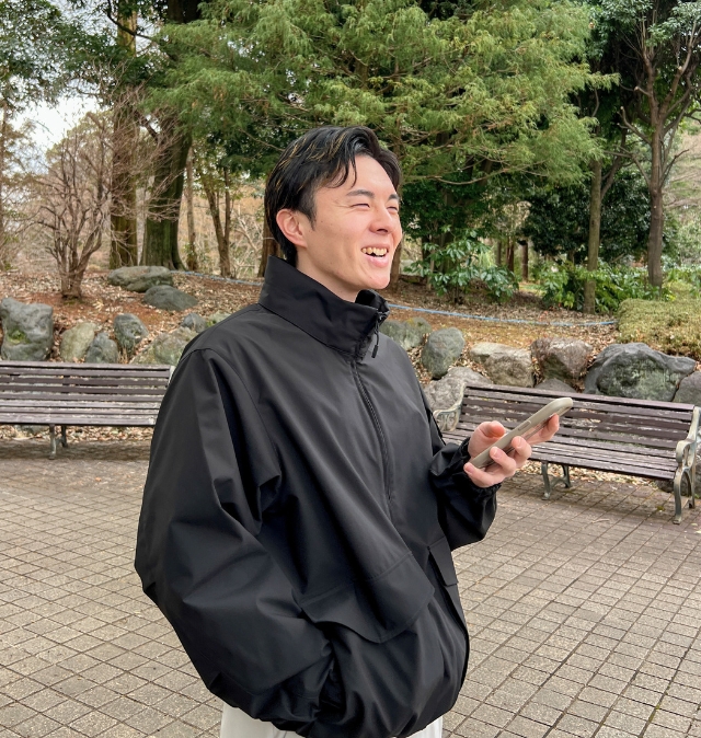 公園でスマホを見る日常の一場面を切り取った、自然な他撮り風の写真