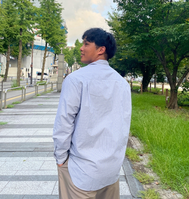 歩きながら振り返る自然な仕草で、人柄と親しみやすさを伝える写真